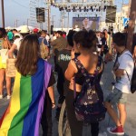 Una joven con la bandera con los colores del arco iris.