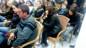 Una mujer, acompañada por su hija, toma la palabra durante la reunión.
