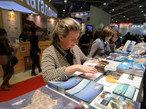Una visitante a la Feria de Moscú observa el material promocional de Eivissa