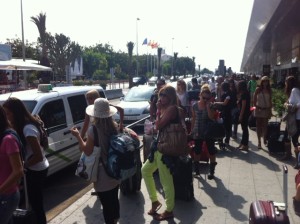 Clientes aguardando a los taxistas frente a la terminal del aeropuerto.