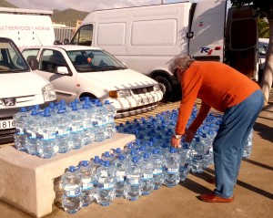 Un vecino recoge dos garrafas de agua potable embotellada en una jornada de protesta en Sant Jordi por la mala calidad del agua. 