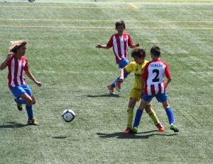 Tres jugadores del Vallbonense presionan a un futbolista del Villarreal alevín.