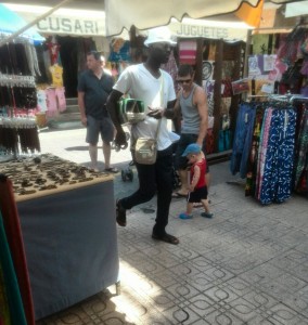 Un vendedor ambulante pasa por entre los puestos de la calle Sant Mateu.