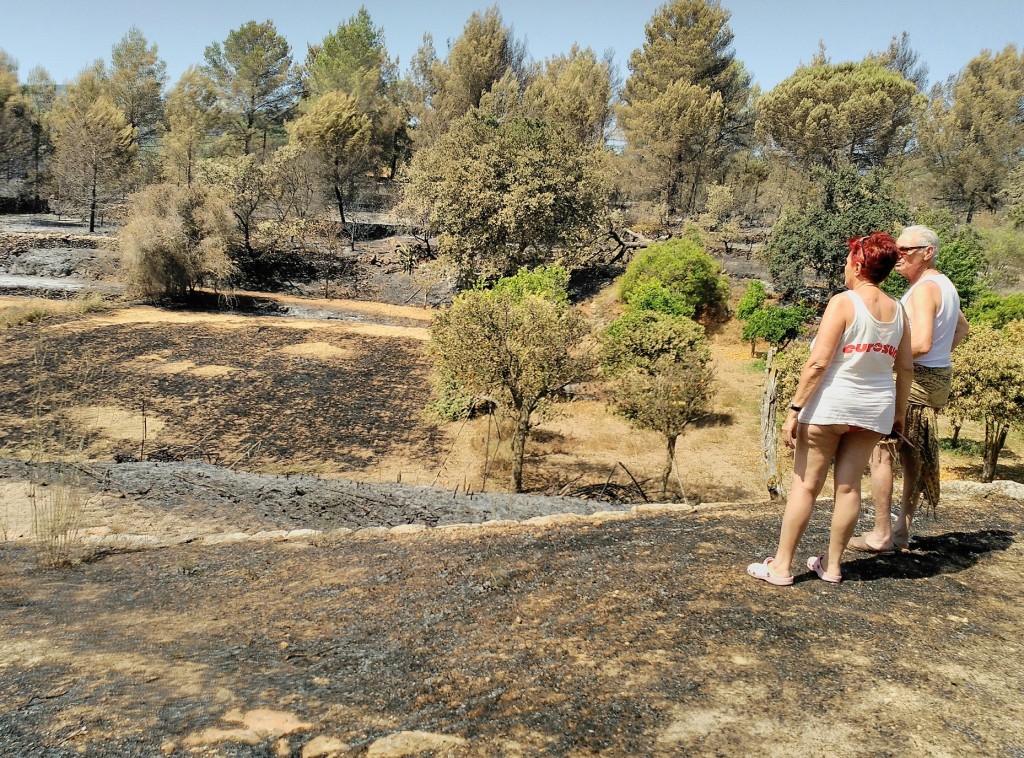 Los residentes de Can Tonicus observando el paisaje quemado que rodea su casa. Foto: D.V.