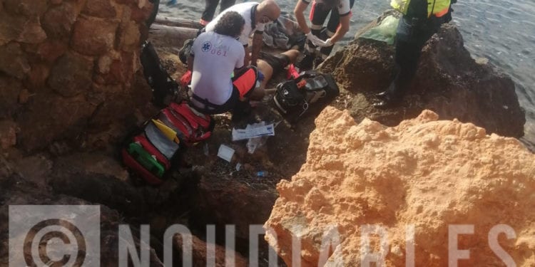 Los sanitarios tratan de reanimar al joven sobre las rocas