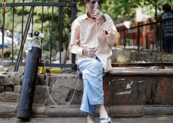 Un hombre enfermo recibe oxígeno en una calle de India hace unos días, en plena ola de Covid. Foto de Ninian Reid de Flickr