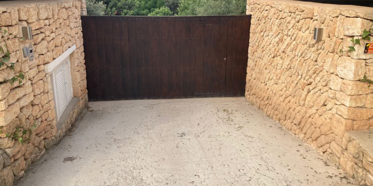 Portón de entrada a una vivienda de la zona de es Cubells donde los vecinos denuncian que ha habido repetidas fiestas ilegales este año.