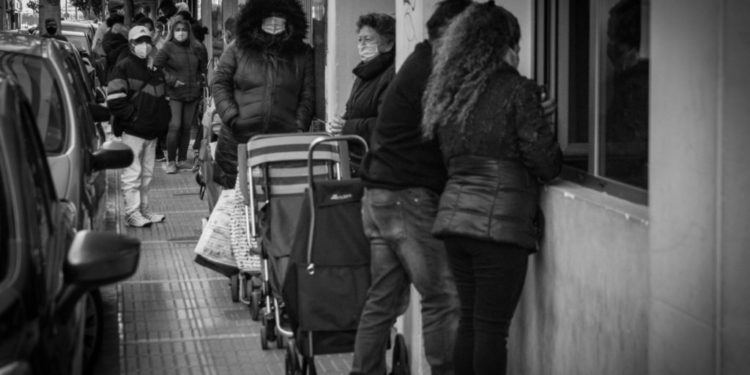 Cola de personas acudiendo a por alimentos a Cáritas Ibiza en invierno.