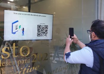 Un usuario lee un QR en una pantalla gestionada por Admefy.