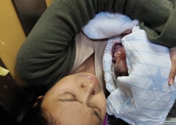 La madre y el pequeño Lian recién nacido y envuelto en una mantita en el ascesor de la vivienda. Foto Vicent M. Yern