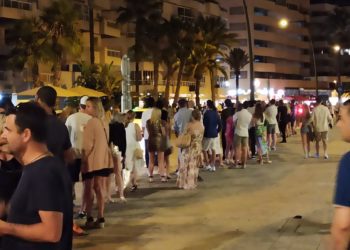 Larga cola de turistas esperando un taxi en el puerto de Ibiza