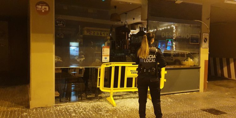 La Policía Local de Ibiza en la puerta del local con una valla para proteger la puerta completamente reventada. Foto Noudiari