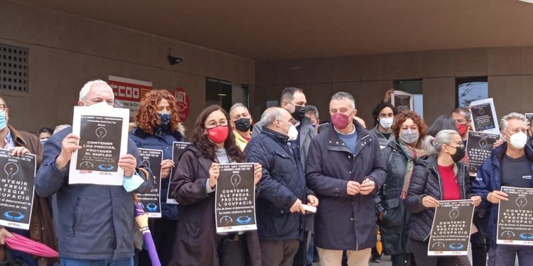 Alfonso Rojo, presidente de la Pimeef, con mascarilla granate charla con Fernando Fernández, secretario general de UGT de las Pitiüses rodeados de otros asistentes a la concentración.