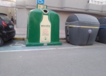 El contenedor de vidrio ocupa una plaza de aparcamiento para personas con discapacidad.