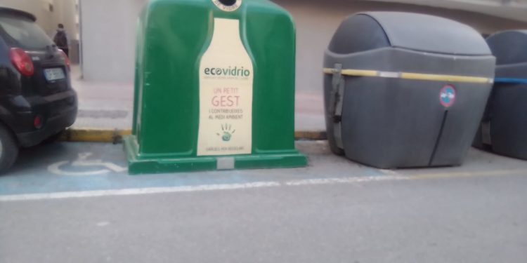 El contenedor de vidrio ocupa una plaza de aparcamiento para personas con discapacidad.