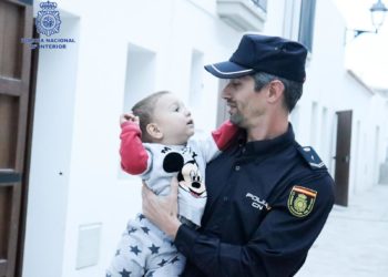 El menor con el agente que le salvó la vida. Foto Policía Nacional