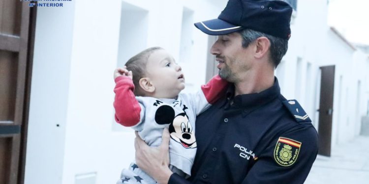 El menor con el agente que le salvó la vida. Foto Policía Nacional