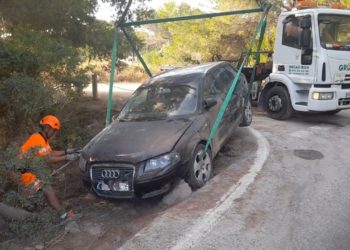 El coche, dentro de la zanja en la que ha caído, rescatado por Grúas Ibiza.