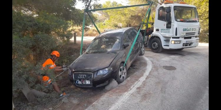El coche, dentro de la zanja en la que ha caído, rescatado por Grúas Ibiza.