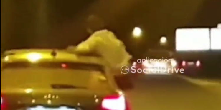 Captura del vídeo en el que se puede ver a una persona con medio cuerpo fuera de la ventanilla en un coche en circulación por Ibiza