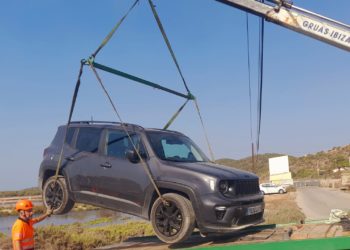 Un equipo de Grúas Ibiza extrae el coche del canal de Es Cavallet