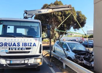 Una pluma de Grúas Ibiza retira el coche estampado contra el puente elevado