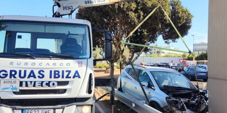 Una pluma de Grúas Ibiza retira el coche estampado contra el puente elevado