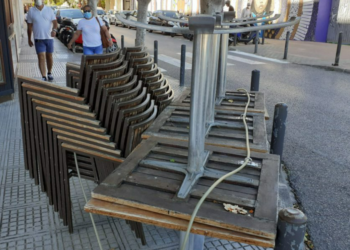 Imagen de archivo de mesas y sillas de una terraza recogidas.