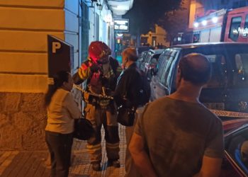 Un bombero habla con los propietarios del negocio