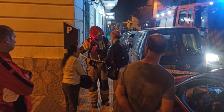 Un bombero habla con los propietarios del negocio