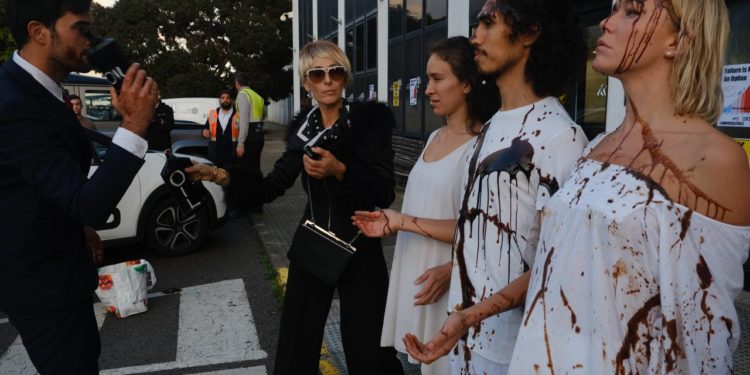 Personajes caracterizados como 'ricos' lanzan un líquido negro que simula petróleo sobre unos personajes de blanco que representan Ibiza.