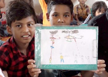 Unos niños muestran un dibujo de lo que han vivido. Pauxa Films