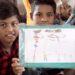 Unos niños muestran un dibujo de lo que han vivido. Pauxa Films