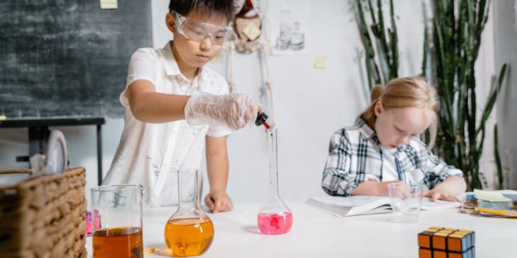 Niños y niñas haciendo experimentos. Foto Pexels