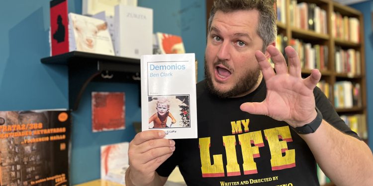 Ben Clark, en la librería salmantina Letras Corsarias, en una divertida pose con su libro 'Demonios'. Foto Mariano Acosta