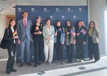 Carlie, en el centro de la imagen con la bandera australiana y junto a la embajadora de ese país, Sophia McIntyre, posa junto al resto de ganadoras y Hugh Elliott, embajador de Reino Unido.