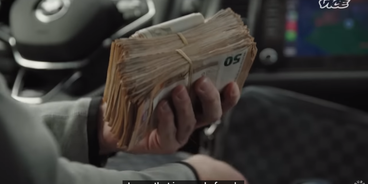 El vendedor de droga muestra a la cámara un fajo de billetes. Imagen de VICE