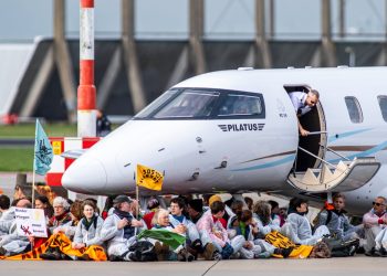 Activistas climáticos bajo un avión privado en el Aeropuerto de Ámsterdam-Schiphol
el 5 de noviembre de 2022. Foto de Greenpeace