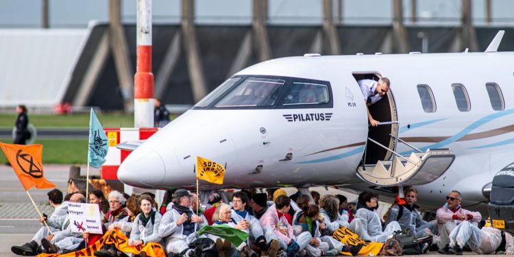 Activistas climáticos bajo un avión privado en el Aeropuerto de Ámsterdam-Schiphol
el 5 de noviembre de 2022. Foto de Greenpeace