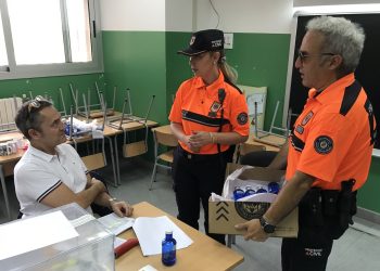 Daniela T. y Rafa Verdugo, de Protección Civil, reparten agua y bocadillos en el CEIP Sant Agustí.
