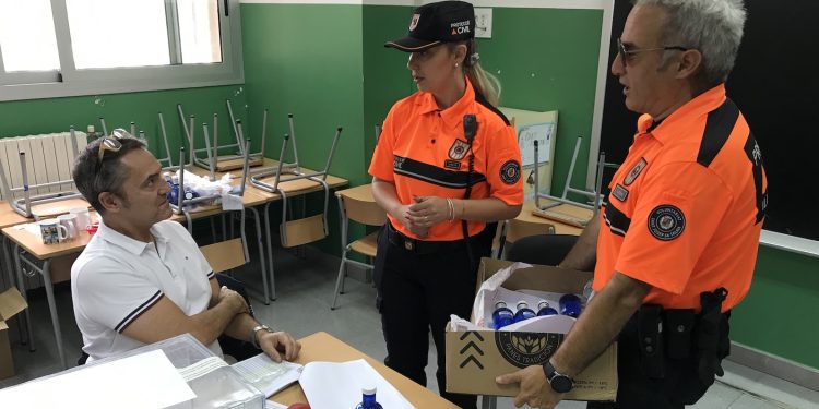 Daniela T. y Rafa Verdugo, de Protección Civil, reparten agua y bocadillos en el CEIP Sant Agustí.