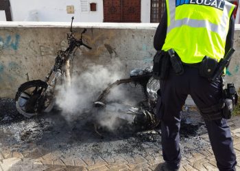 Miembros de la Policía Local, apagando la moto en llamas.