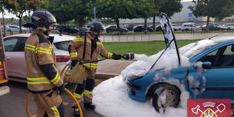 Los bomberos del parque insular de Ibiza sofocando esta mañana el incendio en el motor del coche aparcado. Foto Bombers d'Eivissa