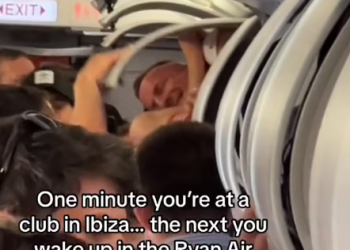 Hombre en el compartimento del equipaje de mano en un vuelo de Ibiza. Imagen Dom Dolla