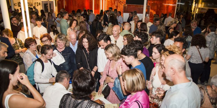 El autor firma libros a la izquierda de la imagen rodeado de asistentes al acto en el hall del Centro Cultural de Jesús. Foto Toni Costa