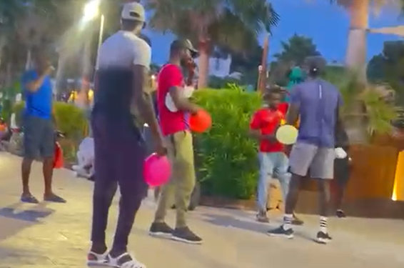 Una imagen captada discretamente de los vendedores de gas de la risa delante de un establecimiento de ocio de Sant Antoni. Hay empresarios que han recibido amenazas por quejarse o recriminarles su actitud. Fotos Noudiai