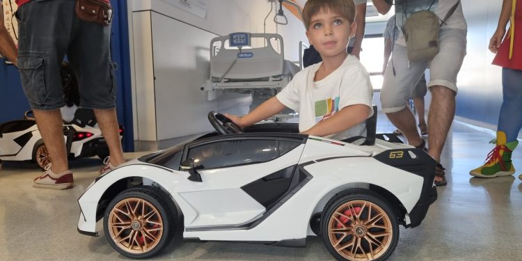 Un paciente de Pediatría, al volante de uno de los coches donados por el Colegio Mestral a Can Misses.