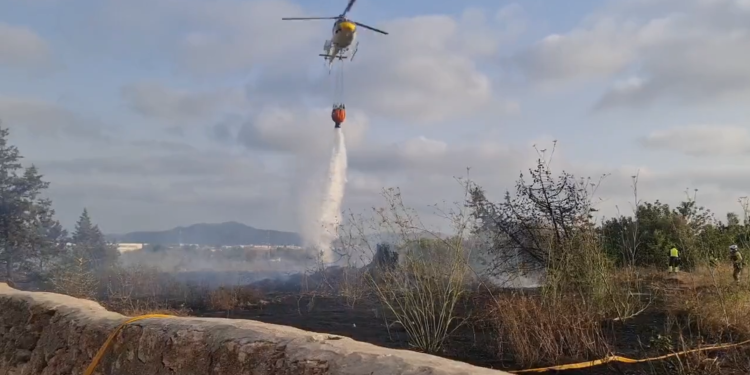 Imagen del helicóptero del Ibanat descargando agua sobre la zona. Foto: @Bombersdeivissa