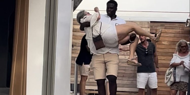 El personal de seguridad con una activista en el momento del desalojo del Blue Marlin.