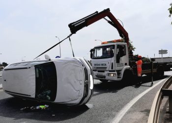 Operarios de Grúas Ibiza retiran el vehículo siniestrado esta mañana de lunes en la carretera del aeropuerto.